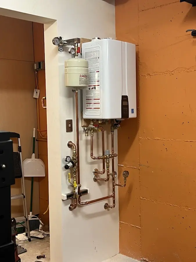 Plumbing technician inspecting water heater connections in Clute